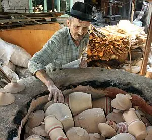 fotografie olar care pregateste cuptor pentru ars ceramica